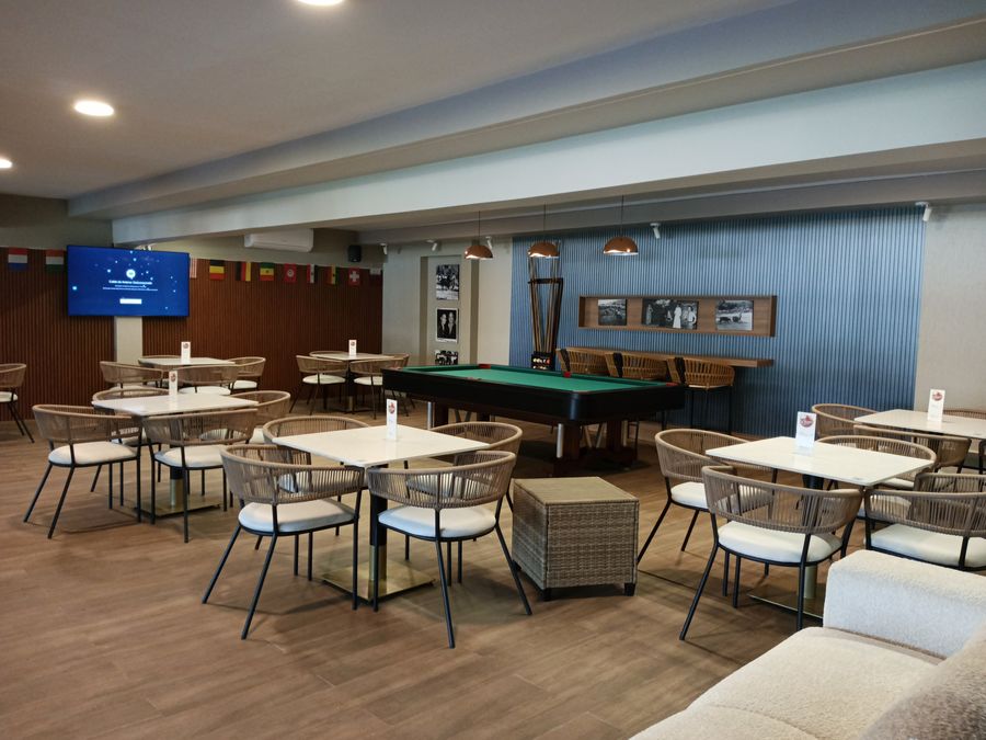 Salón con las mesas puestas y la barra al fondo